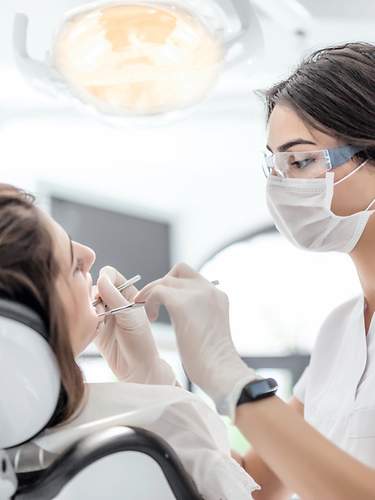 Eine Frau wird von einer Zahnärztin untersucht.