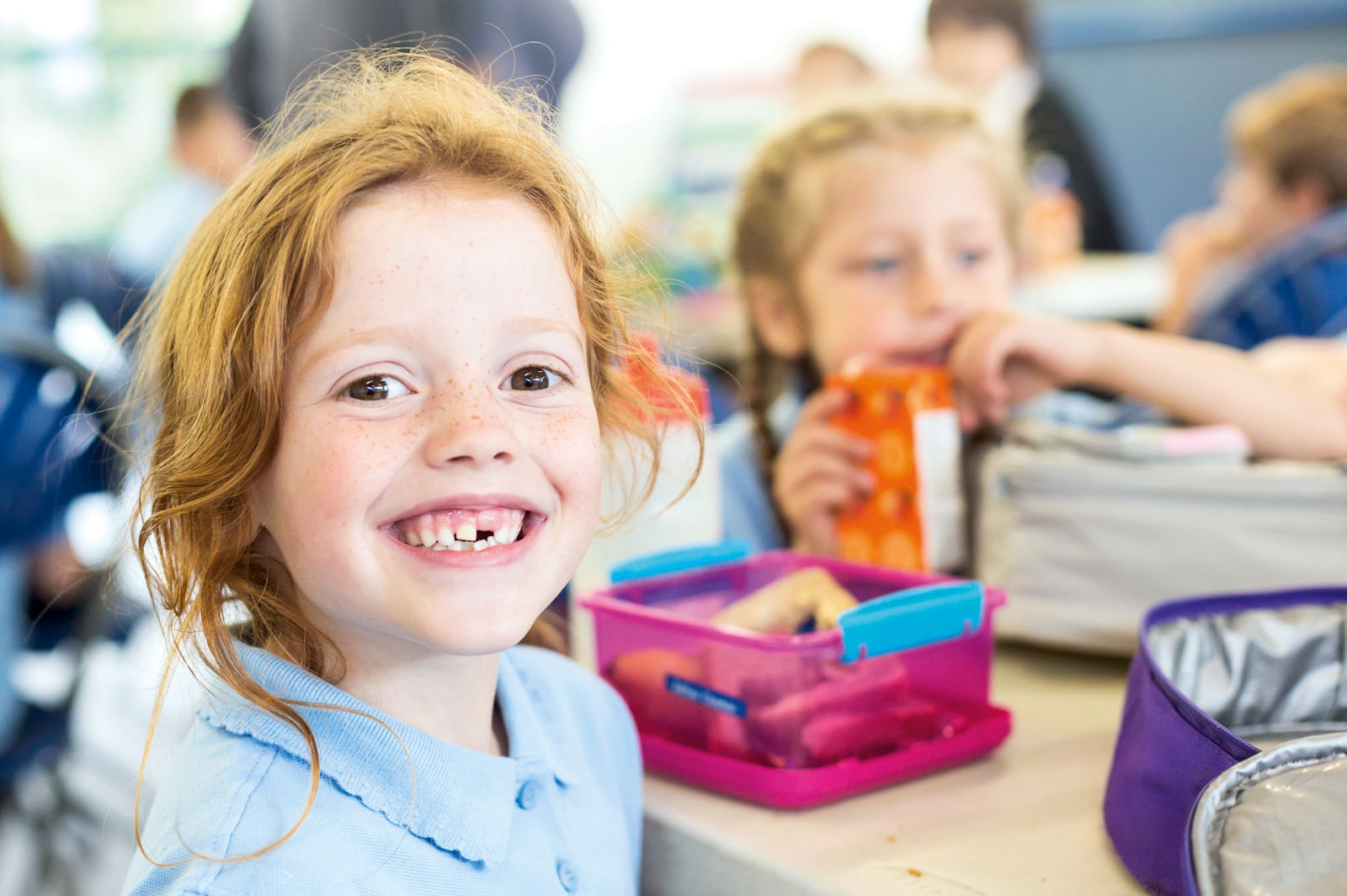 Zahnzusatzversicherung für Kinder mit Kieferorthopädie Ein Mädchen mit Zahnlücke lächelt
