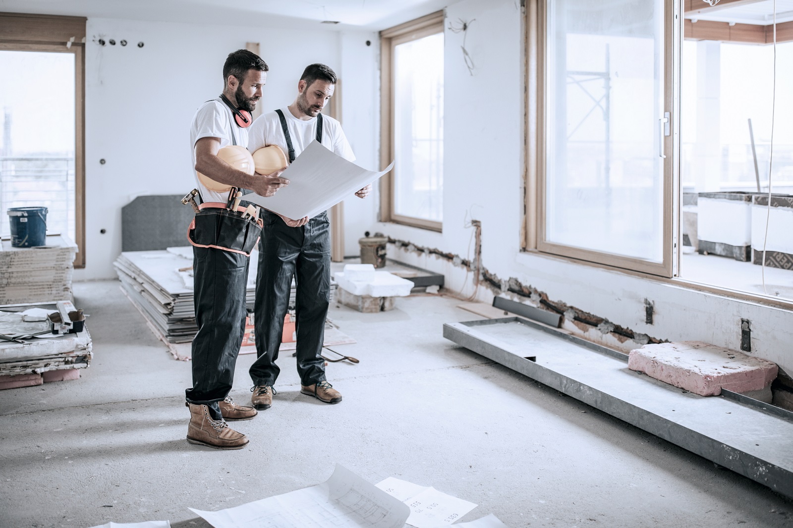 Zwei Baugutachter kontrollieren den Fortschritt beim Hausbau.