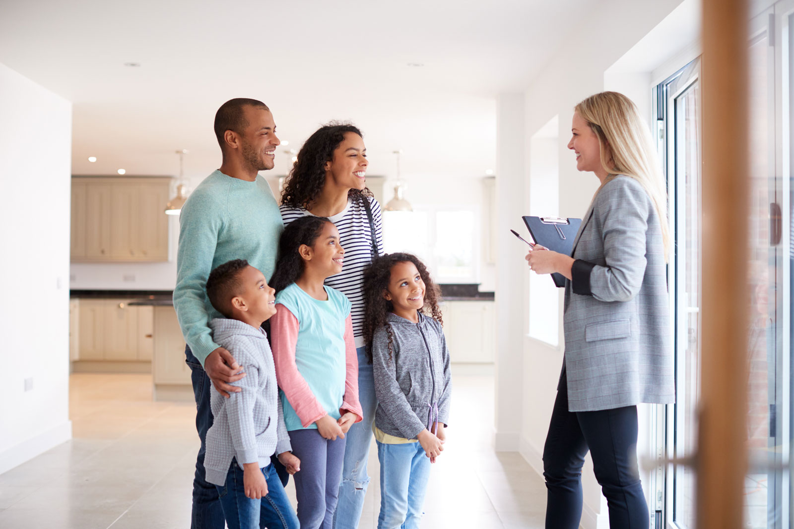 Wen sollte ich mitnehmen, wenn ich ein Haus besichtigen möchte? Eine junge Familie ist gemeinsam mit ihren Kindern bei einer Hausbesichtigung.