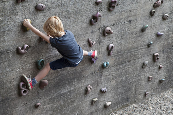 Ein Junge klettern in der Wand