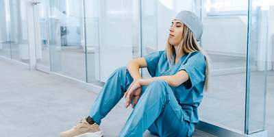 am Boden sitzende Pflegerin