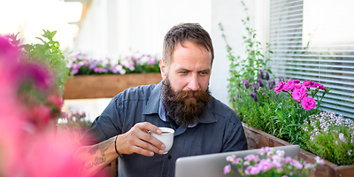 Mann mit Tochter auf den Schultern arbeitet am PC