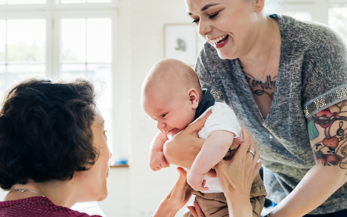 Zwei Frauen freuen sich mit einem Baby