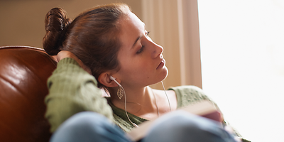 Eine junge Frau hört sich das Familienhörbuch an