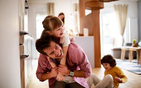 Eine Mutter gibt ihr Baby in die Arme der Oma.