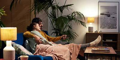 Ein Paar hat es sich auf der Couch gemütlich gemacht.