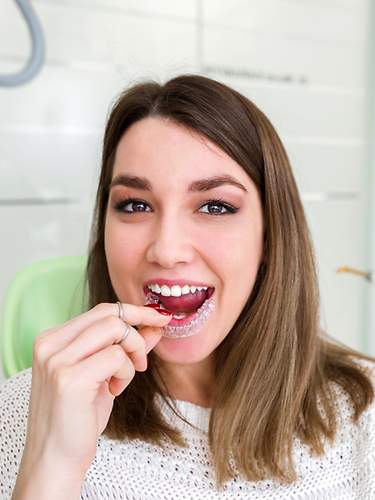 Das Bild zeigt eine Frau mit Schiene beim Zahnarzt. 