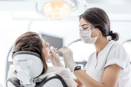 Eine Frau wird von einer Zahnärztin untersucht.