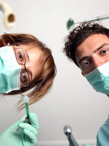Das Bild zeigt eine Zahnärztin und einen Arzthelfer aus Sicht eines Patienten, der eine Vollnarkose erhält.
