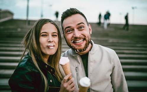 Ein Paar isst glücklich Eis, nachdem einer der beiden eine Wurzelbehandlung durchführen ließ.