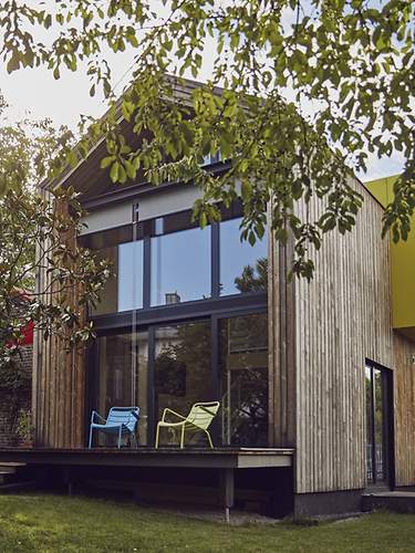 Ein modernes Einfamilienhaus mit Garten, das mit einer Immobilienversicherung versichert ist.