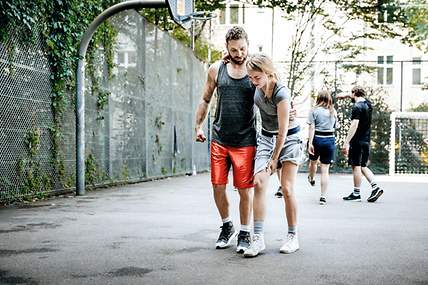 Eine Frau wird nach einem Sportunfall von einem Mann gestützt. 