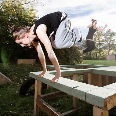 Frau springt durch ihren Parkour
