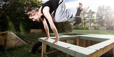 Frau springt durch ihren Parkour