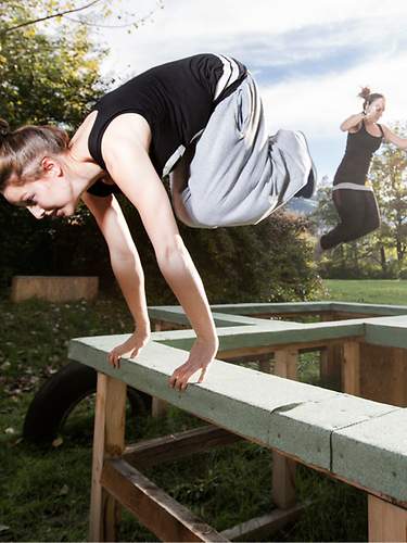 Frau springt durch ihren Parkour