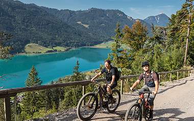 Zwei Biker fahren bei schönstem Wetter durch die Berge