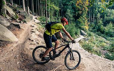 Ein Mountainbiker fährt konzentriert um eine Kehre.