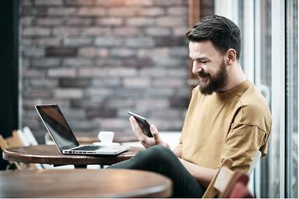 Ein Mann sitzt in einem Café und informiert sich über Versicherungen bei der Steuererklärung.