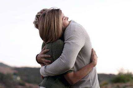 Ein Mann und eine Frau, die eine Todesfallversicherung abgeschlossen haben, umarmen sich.