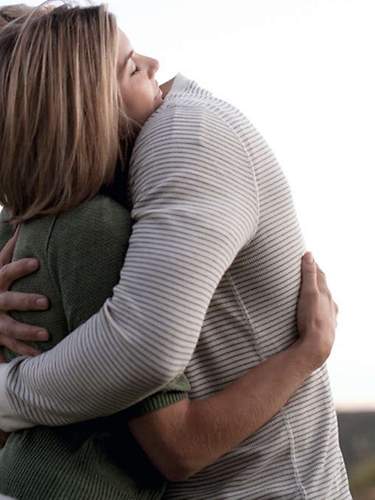 Ein Mann und eine Frau, die eine Todesfallversicherung abgeschlossen haben, umarmen sich.