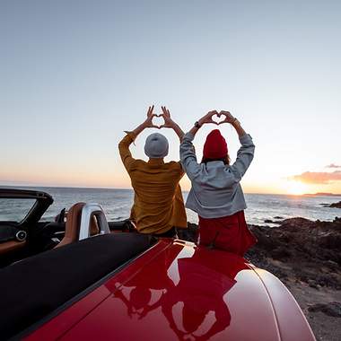 Paar im Sonnenuntergang mit Cabriolet