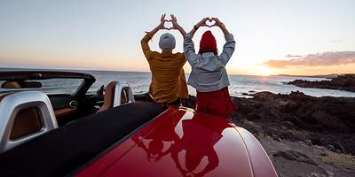 Paar im Sonnenuntergang mit Cabriolet