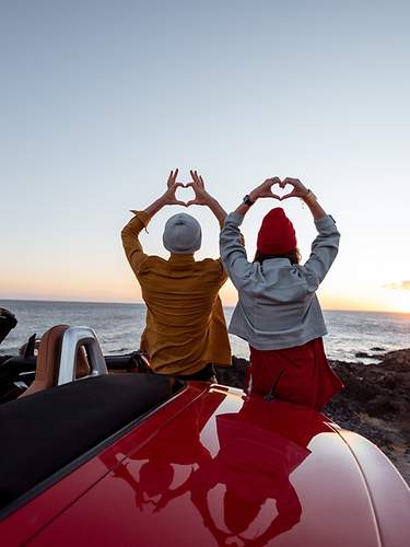 Paar im Sonnenuntergang mit Cabriolet