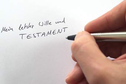 Eine Person schreibt in ihr Testament, wie der digitale Nachlass verwaltet werden soll.