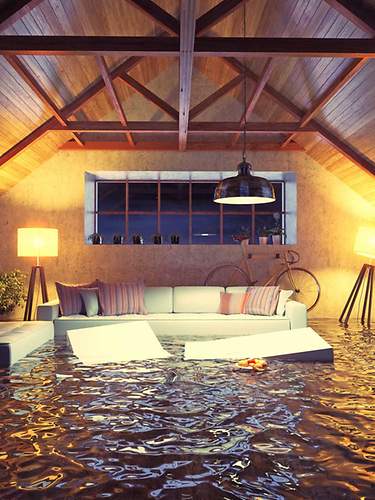 Das Bild zeigt eine Überschwemmung im Wohnzimmer aufgrund von Hochwasser. 