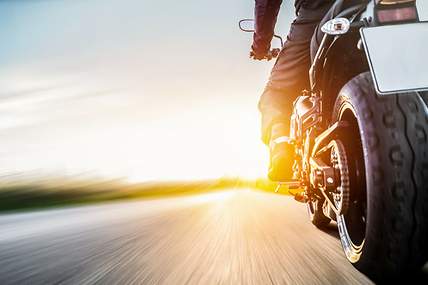 Eine Frau hat ihr Smartphone und Unterlagen in der Hand, weil sie ihre Motorradversicheurng kündigen möchte.