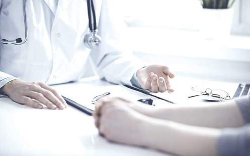 BU & Psychotherapie Ein Arzt füllt ein Formular für die Berufsunfähigkeitsversicherung aus.