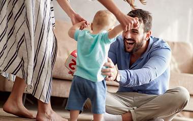 Vater, Mutter und Kind spielen unbeschwert Ein Paar hat mit einer Risikolebensversicherung für sein Kind vorgesorgt.