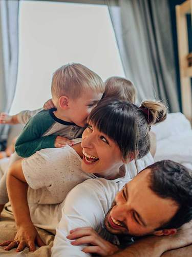 Ein Paar mit 2 Kindern ist glücklich zuhause.