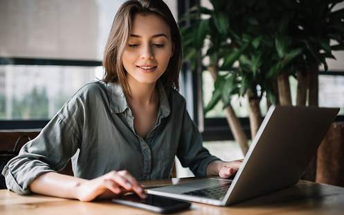 Eine Frau prüft am Laptop, ob sie bei ihrer Versicherung sparen kann.