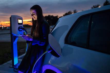 Eine Frau lädt ihren Tesla auf.