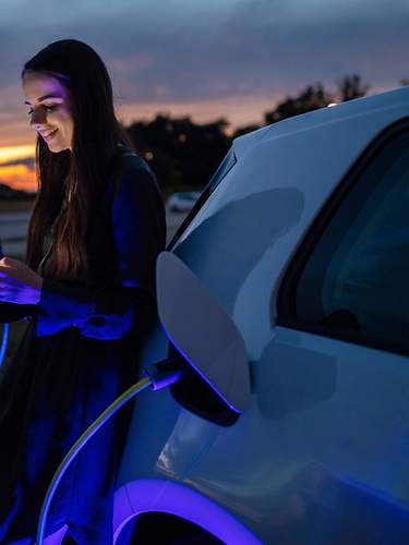 Eine Frau lädt ihren Tesla auf.