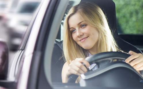 Das Bild zeigt eine junge Frau im Auto, die sich keine Sorgen um die VW Golf 4 Versicherung für Fahranfänger macht.