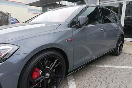 Eine junge Frau steigt lachend aus ihrem Auto.