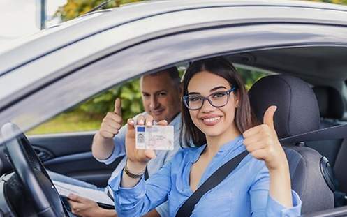 Fahranfängerin hält Führerschein in der Hand