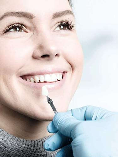 Das Bild zeigt eine Frau, deren Zahnkrone in der Zahnzusatzversicherung abgedeckt ist.