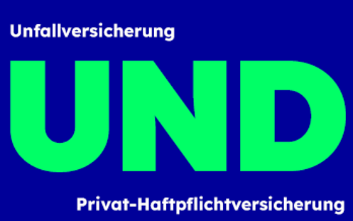 Bei der Abfahrt auf einer Piste springt ein Skifahrer von einem kleinen Felsen.