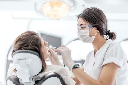 Patientin wird von Zahnärztin untersucht. 
