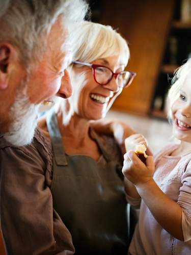 Großeltern mit abgeschlossener Sterbegeldversicherung ohne Wartezeit verbringen Zeit mit ihrer Enkelin. 