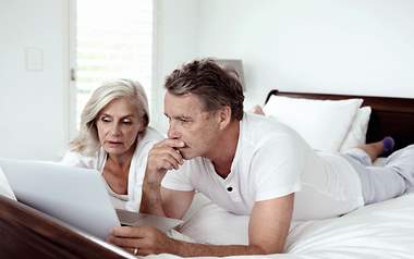 Für diese Personen lohnt sich eine Sterbeversicherung am meisten Ein Paar redet am Laptop über sinnvolle Anbieter für die Sterbegeldversicherung.