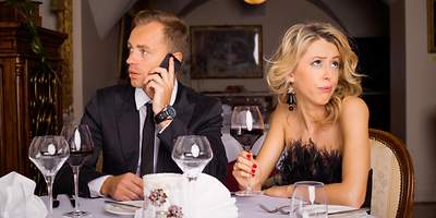 Während eines Dates ist der Mann am telefonieren und die Frau guckt genervt. 