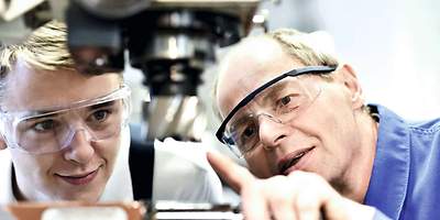 Zwei Personen schauen sich eine Maschine an