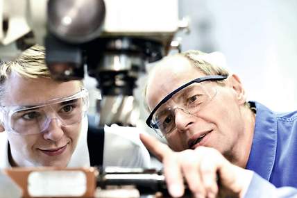 Zwei Personen schauen sich eine Maschine an