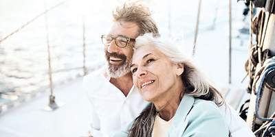 Diese Policen brauchen Rentner & Pensionäre Ein Ehepaar im Ruhestand umarmt sich.