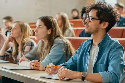 Versicherungen für Studenten. Eine Gruppe von Studenten spaziert über einen Weg.